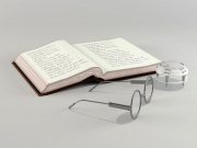 Book, retro glasses and lens